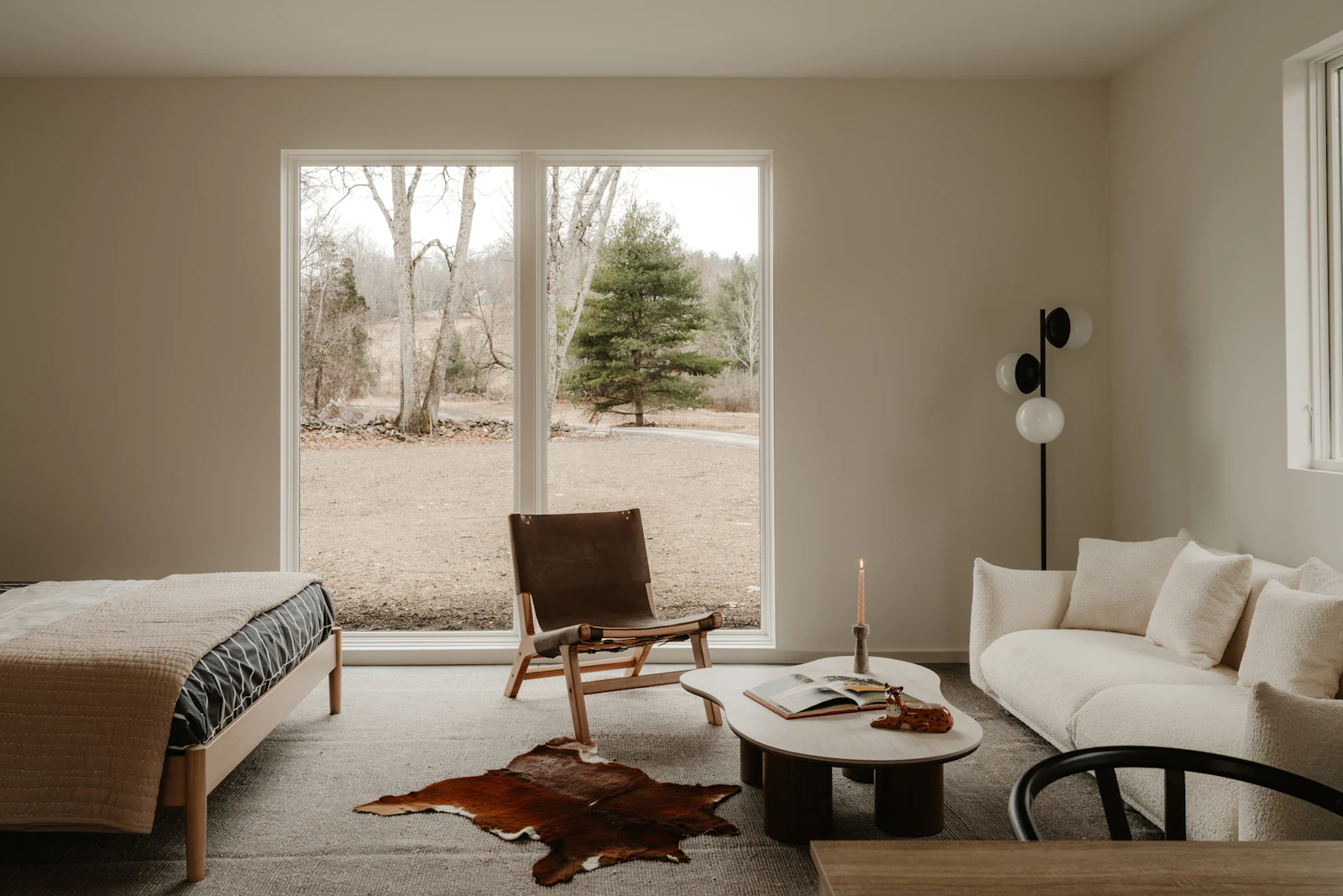 A small open living space with a full-height window looking onto planting